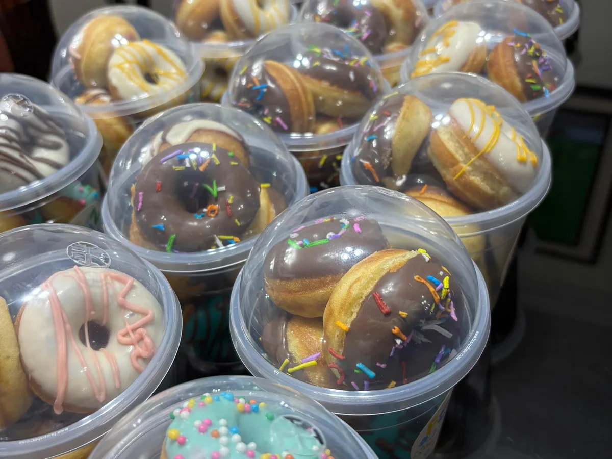 Cajas abiertas con minidonas glaseadas y decoradas.