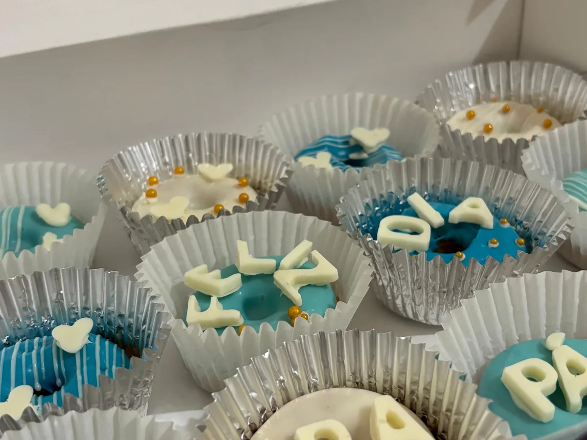 Minidonas decoradas en azul y blanco dentro de una caja.